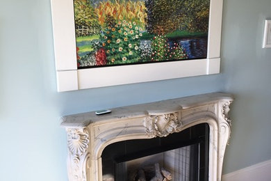 Ejemplo de sala de estar tradicional de tamaño medio con paredes azules, suelo de madera clara, marco de chimenea de piedra y televisor retractable