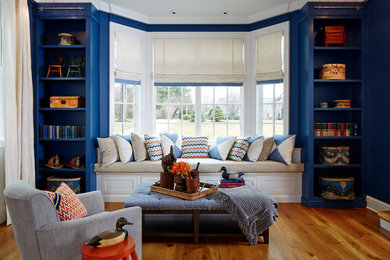 Large elegant open concept medium tone wood floor family room photo in New York with blue walls