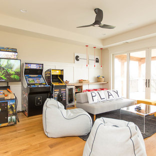 Immagine di un grande soggiorno minimal con sala giochi, pareti bianche, parquet chiaro e parete attrezzata