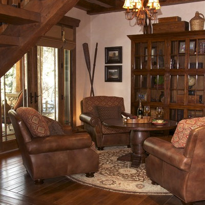 Example of a mountain style dark wood floor family room design in San Diego with beige walls