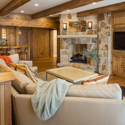 Mountain style open concept medium tone wood floor and brown floor family room photo in Minneapolis with a bar, brown walls, a corner fireplace, a stone fireplace and a media wall