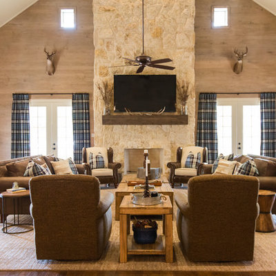 Family room - large rustic open concept medium tone wood floor and brown floor family room idea in Houston with a standard fireplace, a stone fireplace, a wall-mounted tv and beige walls