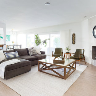 Inspiration for a large contemporary open plan games room in Los Angeles with white walls, porcelain flooring, a standard fireplace, a concrete fireplace surround and beige floors.