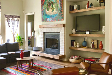 Example of a mid-sized eclectic light wood floor family room design with green walls, a standard fireplace and a brick fireplace