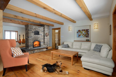 Foto de sala de estar con rincón musical abierta rural con paredes blancas, suelo de madera clara, chimenea de doble cara y marco de chimenea de piedra