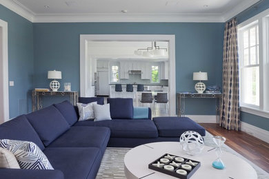 Modelo de sala de estar cerrada tradicional renovada de tamaño medio con paredes azules y suelo de madera oscura