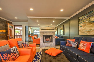 Mittelgroßes, Offenes Modernes Wohnzimmer mit brauner Wandfarbe, hellem Holzboden, Kamin, Kaminumrandung aus Backstein, TV-Wand und braunem Boden in Orange County
