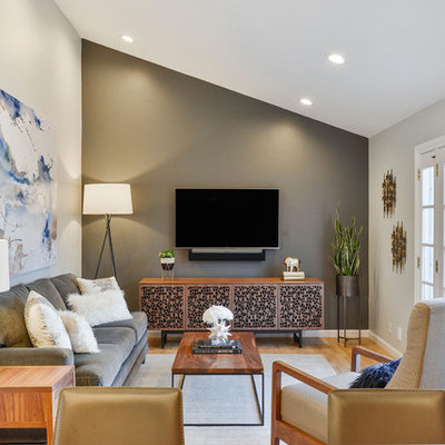 Mid-sized transitional light wood floor family room photo in San Francisco with gray walls, no fireplace and a wall-mounted tv