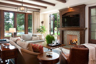 Family room - mediterranean family room idea in San Diego with white walls, a media wall, a standard fireplace and a tile fireplace