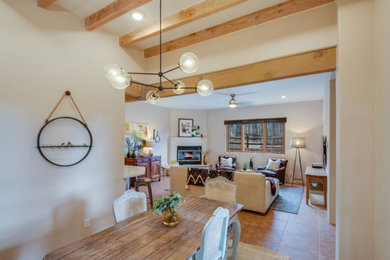 Ejemplo de sala de estar abierta de estilo americano grande con paredes blancas, suelo de baldosas de terracota, chimenea de esquina y marco de chimenea de yeso