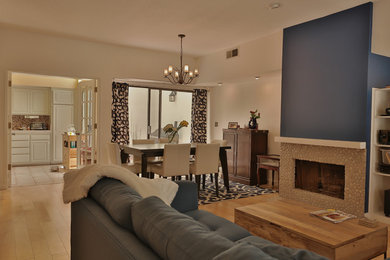 Exemple d'une salle de séjour bord de mer de taille moyenne et ouverte avec un mur blanc, parquet clair, une cheminée standard, un manteau de cheminée en carrelage et un téléviseur encastré.
