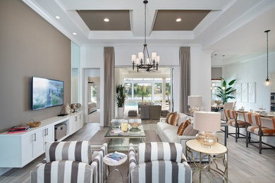 Example of a mid-sized transitional open concept porcelain tile and gray floor family room design in Miami with white walls and a wall-mounted tv