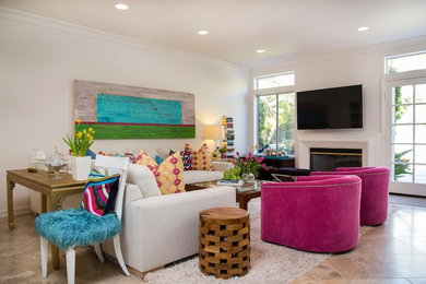 Example of a mid-sized eclectic open concept travertine floor and gray floor family room design in San Diego with white walls, a standard fireplace, a stone fireplace and a wall-mounted tv