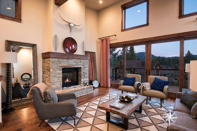 Imagen de sala de estar abierta contemporánea grande sin televisor con paredes beige, suelo de madera en tonos medios, todas las chimeneas y marco de chimenea de piedra