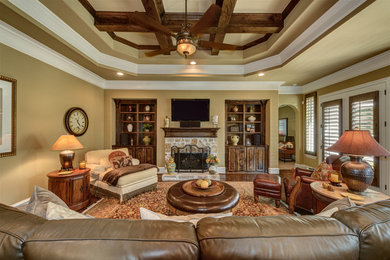 Offenes, Großes Klassisches Wohnzimmer mit brauner Wandfarbe, braunem Holzboden, Kamin, Kaminumrandung aus Stein, TV-Wand und braunem Boden in Dallas