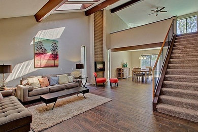 Inspiration for a large midcentury open plan games room in Phoenix with beige walls, no tv, porcelain flooring, a ribbon fireplace and a metal fireplace surround.