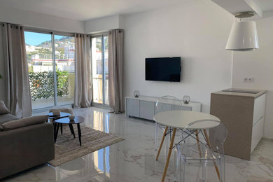Imagen de sala de estar abierta minimalista de tamaño medio con paredes blancas, suelo de mármol, televisor colgado en la pared y suelo blanco