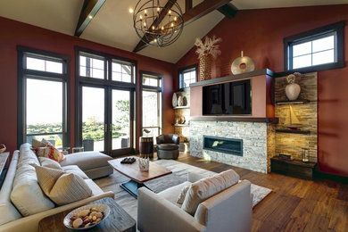 シアトルにある広いコンテンポラリースタイルのおしゃれなファミリールーム (赤い壁、無垢フローリング、横長型暖炉、石材の暖炉まわり、壁掛け型テレビ、茶色い床) の写真