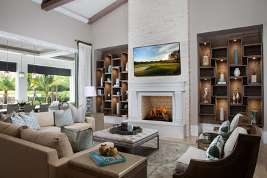 マイアミにある高級な広いトランジショナルスタイルのおしゃれなオープンリビング (ホームバー、白い壁、淡色無垢フローリング、標準型暖炉、石材の暖炉まわり、壁掛け型テレビ、茶色い床) の写真