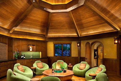 Immagine di un soggiorno stile rurale con angolo bar, pareti gialle e pavimento in legno massello medio