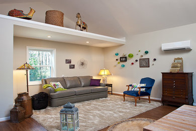 Small trendy enclosed dark wood floor and brown floor family room photo in Raleigh with gray walls and no fireplace