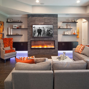 Family room - large transitional enclosed porcelain tile family room idea in Orlando with gray walls, a ribbon fireplace, a stone fireplace and a wall-mounted tv