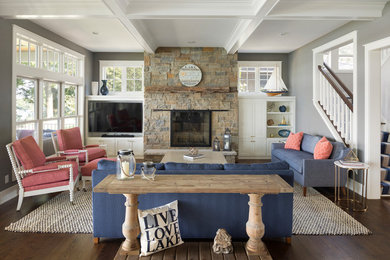 Example of a beach style open concept dark wood floor family room design in Minneapolis with gray walls, a standard fireplace, a stone fireplace and a media wall