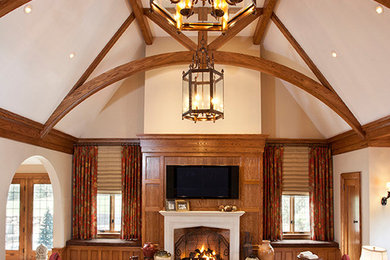 Example of a large transitional enclosed medium tone wood floor and brown floor family room design in Other with beige walls, a standard fireplace, a stone fireplace and a wall-mounted tv