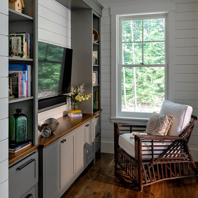 Small arts and crafts enclosed dark wood floor and brown floor family room library photo in Boston with white walls and a media wall
