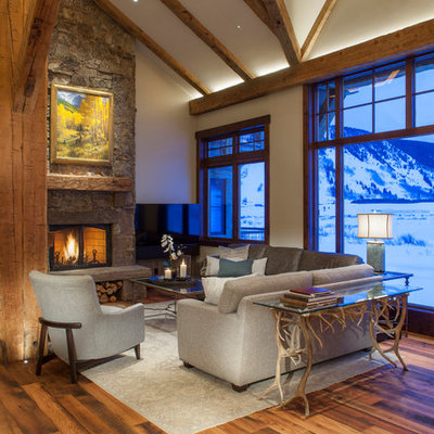 Inspiration for a rustic open concept medium tone wood floor and brown floor family room remodel in Denver with white walls, a standard fireplace, a stone fireplace and a tv stand
