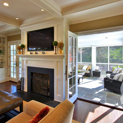 Example of a mid-sized classic enclosed dark wood floor and brown floor family room design in DC Metro with brown walls, a standard fireplace, a media wall and a metal fireplace