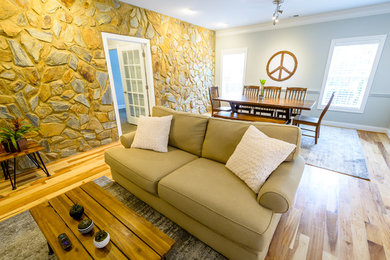 Mittelgroßes, Offenes Landhaus Wohnzimmer ohne Kamin mit grauer Wandfarbe, braunem Holzboden, TV-Wand und braunem Boden in Raleigh
