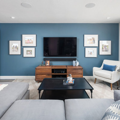 Inspiration for a mid-sized transitional enclosed medium tone wood floor and gray floor family room remodel in San Francisco with no fireplace, a wall-mounted tv and gray walls