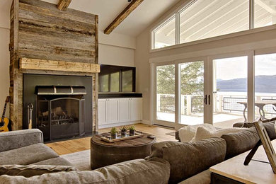 Inspiration for a large craftsman open concept light wood floor family room remodel in Seattle with a wall-mounted tv, white walls, a standard fireplace and a wood fireplace surround