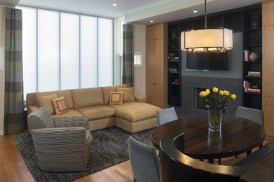 Imagen de sala de estar contemporánea con paredes blancas, suelo de madera clara, marco de chimenea de piedra y pared multimedia