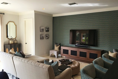 Imagen de sala de estar abierta contemporánea grande sin chimenea con paredes multicolor, suelo de madera clara, televisor colgado en la pared y suelo beige