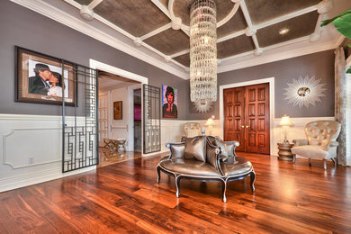 Großes, Offenes Klassisches Wohnzimmer mit grauer Wandfarbe, braunem Holzboden, Kamin, Kaminumrandung aus Stein und TV-Wand in Tampa