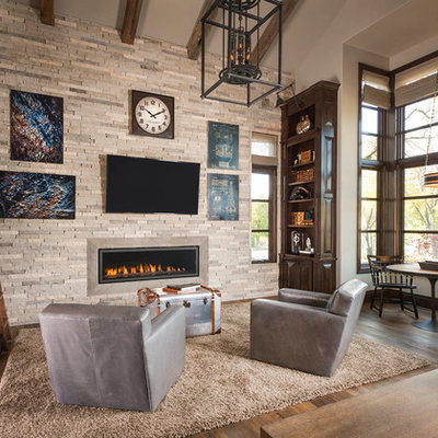 Example of a tuscan enclosed dark wood floor and brown floor family room design in Dallas with beige walls, a ribbon fireplace and a stone fireplace