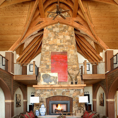 Family room - rustic open concept dark wood floor family room idea in Denver with beige walls, a standard fireplace and a stone fireplace