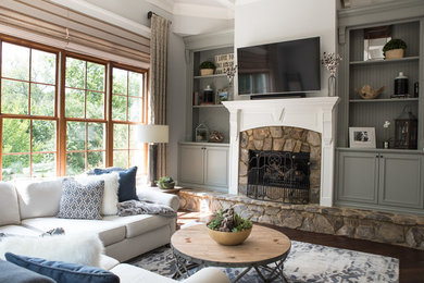Inspiration for a mid-sized transitional open concept dark wood floor and brown floor family room remodel in Charlotte with gray walls, a standard fireplace, a stone fireplace and a wall-mounted tv
