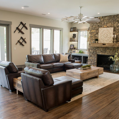 Large mountain style open concept dark wood floor and brown floor family room photo in Charleston with beige walls, a standard fireplace, a stone fireplace and a wall-mounted tv