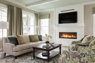 Inspiration for a timeless medium tone wood floor and brown floor family room remodel in Richmond with beige walls, a ribbon fireplace, a wood fireplace surround and a wall-mounted tv