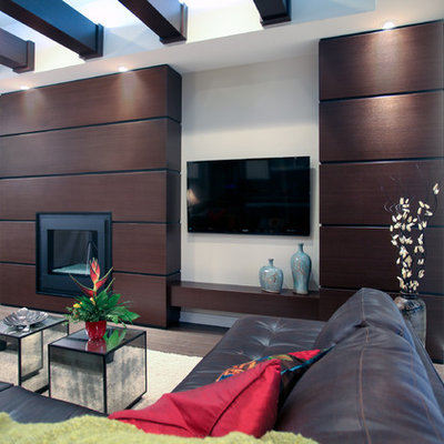 Inspiration for a large contemporary open concept dark wood floor family room remodel in Calgary with a standard fireplace, a wall-mounted tv, white walls and a wood fireplace surround