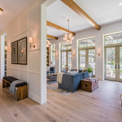 Huge trendy enclosed light wood floor and brown floor family room library photo in Los Angeles with white walls, no tv and no fireplace