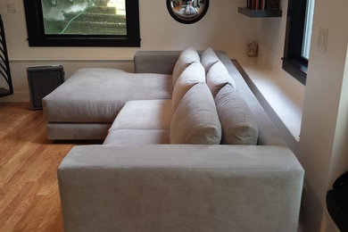 Foto di un soggiorno minimalista di medie dimensioni e aperto con pareti grigie, pavimento in legno massello medio, nessun camino e pavimento marrone