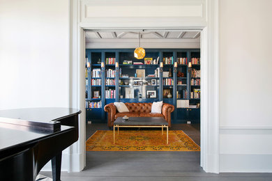 Family room library - large traditional open concept medium tone wood floor and gray floor family room library idea in San Francisco with blue walls