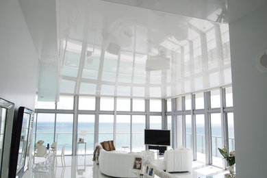 Modelo de sala de juegos en casa abierta moderna grande sin chimenea con paredes blancas, televisor independiente y suelo de mármol