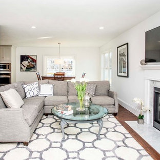 Mid-sized minimalist open concept medium tone wood floor and brown floor family room photo in Boston with gray walls, a standard fireplace, a stone fireplace and a wall-mounted tv