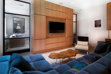 Свежая идея для дизайна: изолированная гостиная комната в современном стиле с белыми стенами, мультимедийным центром и синим диваном - отличное фото интерьера