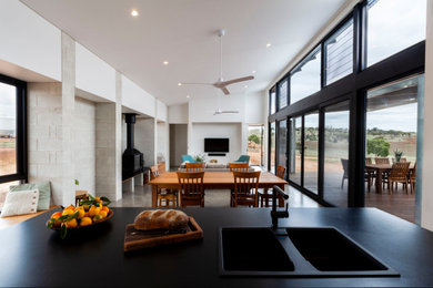 Diseño de sala de estar actual de tamaño medio con suelo de cemento, estufa de leña y suelo gris
